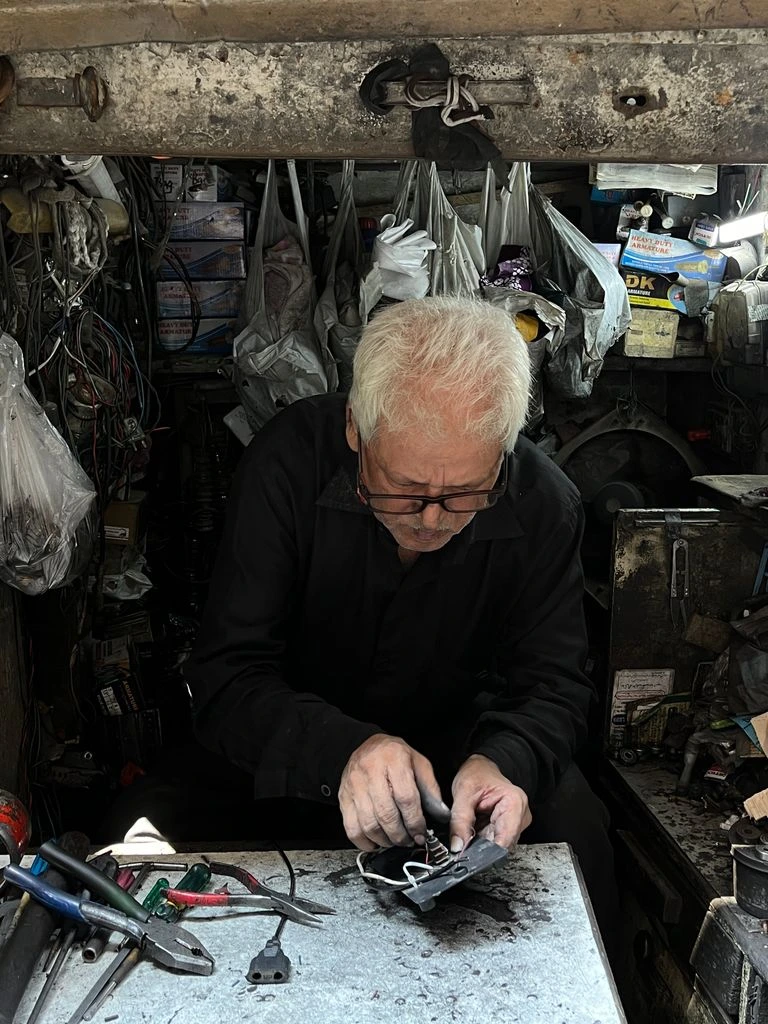 Técnico reparando lavadora industrial en cuarto comunitario